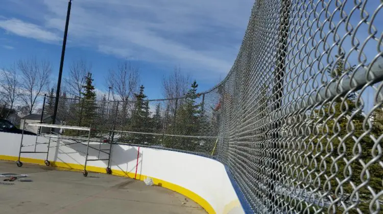 Outdoor hockey rink with chain-link fence.