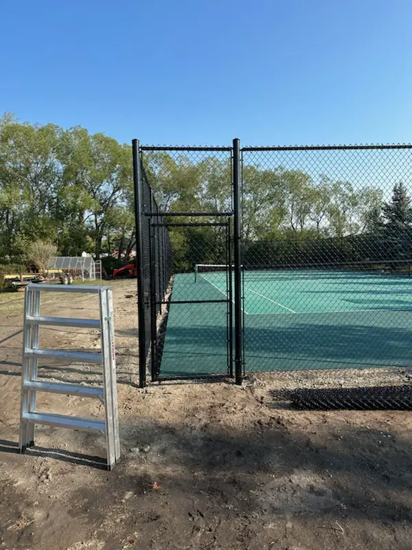 IMG_33761 A partially installed black chain-link fence with a ladder nearby.
